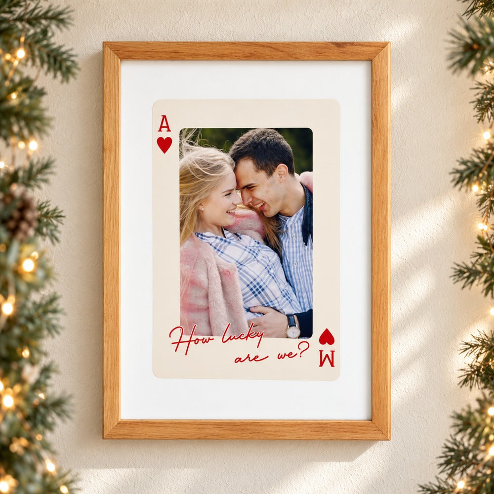 Personalized couple playing card framed print hanging on wall with holiday garland and fairy lights