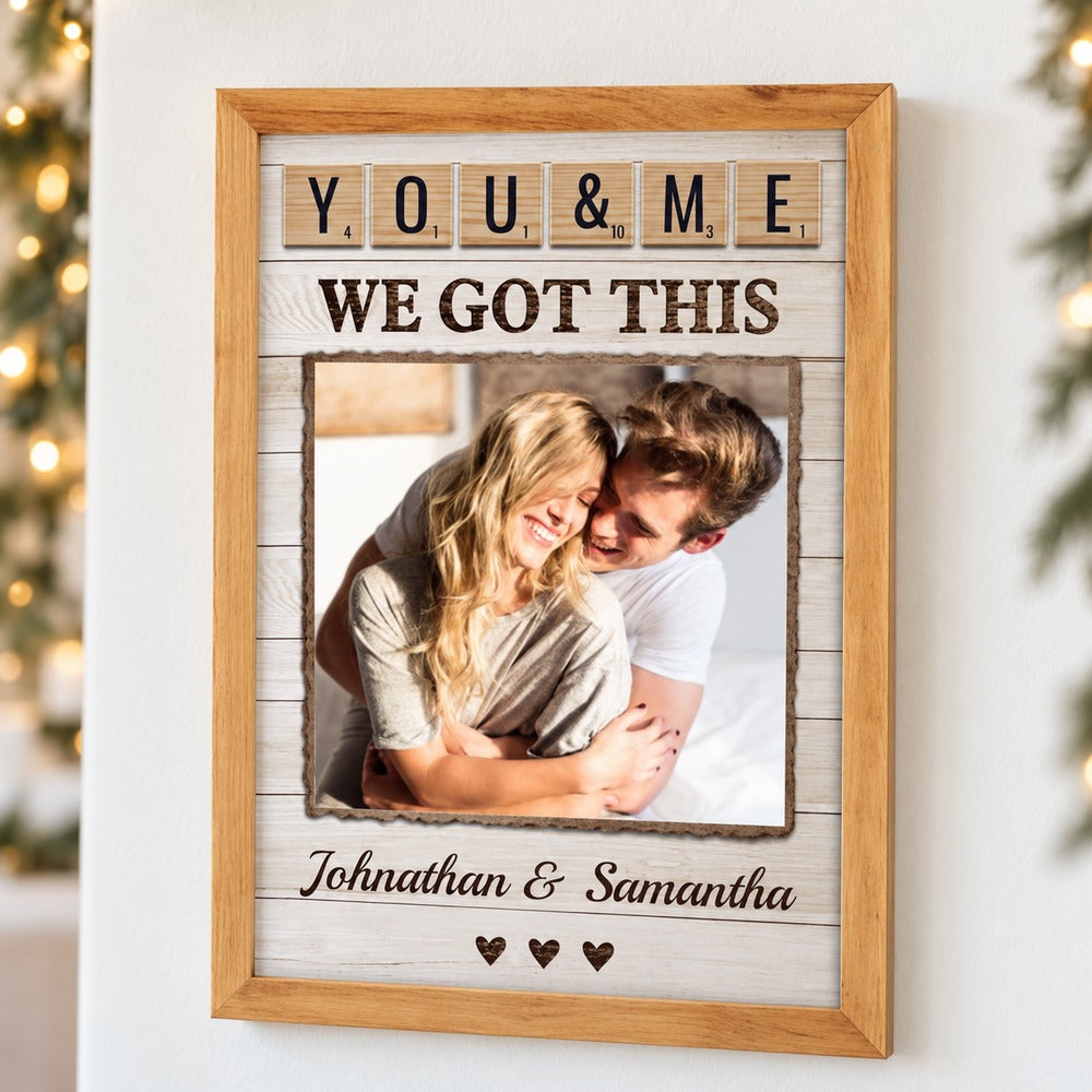 Custom couple framed canvas print hanging on a wall with soft holiday greenery and lights