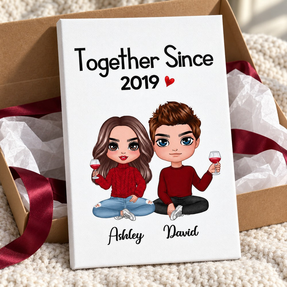 Personalized couple anniversary canvas print nestled with gift box and red ribbon
